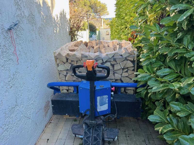 Livraison de bois sec rangé sur palette avec transpalette électrique tous terrains à Roquefort la bédoules