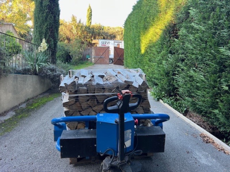Palette de bois de chauffage sec empilée et prête à être livrée à Aix-en-Provence .