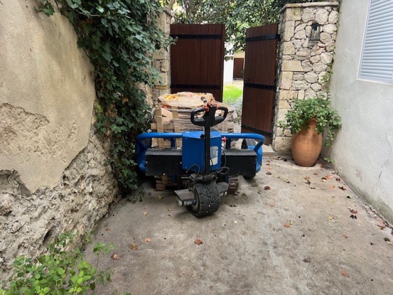 Livraison de bois de chauffage sec rangé sur palette et livré avec transpalette tout terrains, 