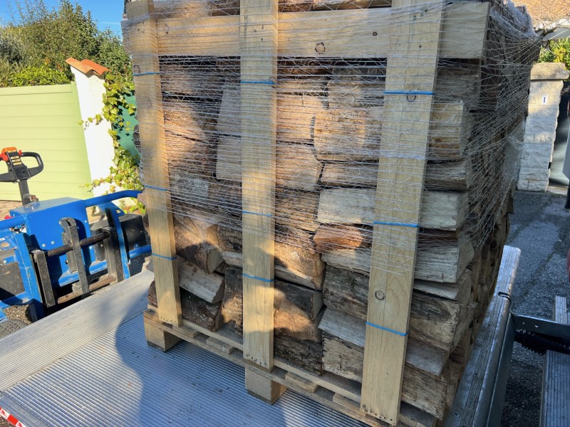 Palette de bois de chauffage sec empilée, prête à être livrée à Roquefort la Bédoule.