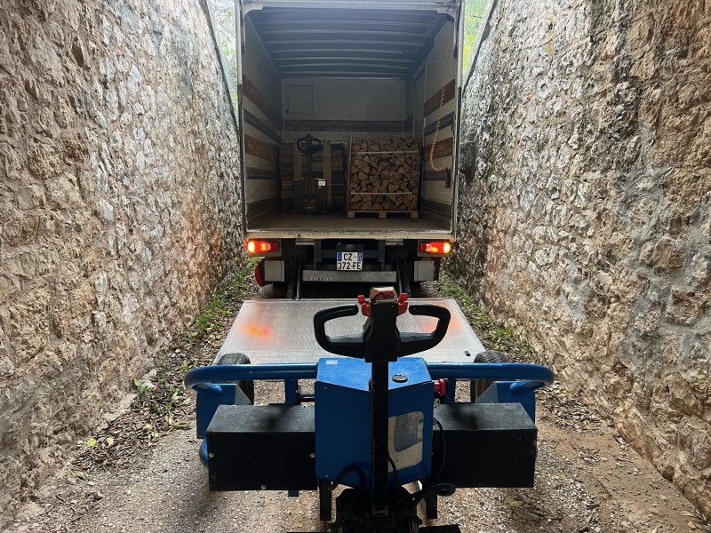 Livraison bois de chauffage sec rangé sur palette avec petit camion